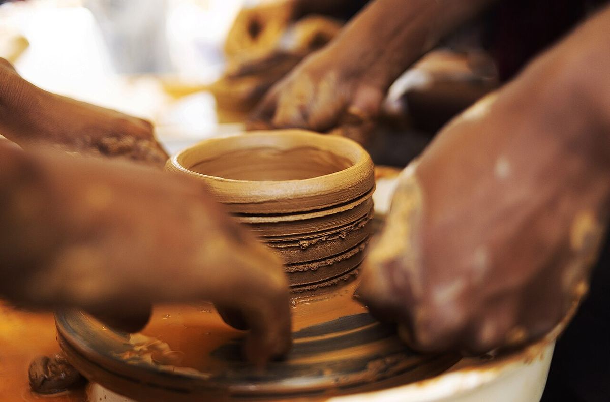 Miniatura: Hands carrying a just sculpted clay bowl